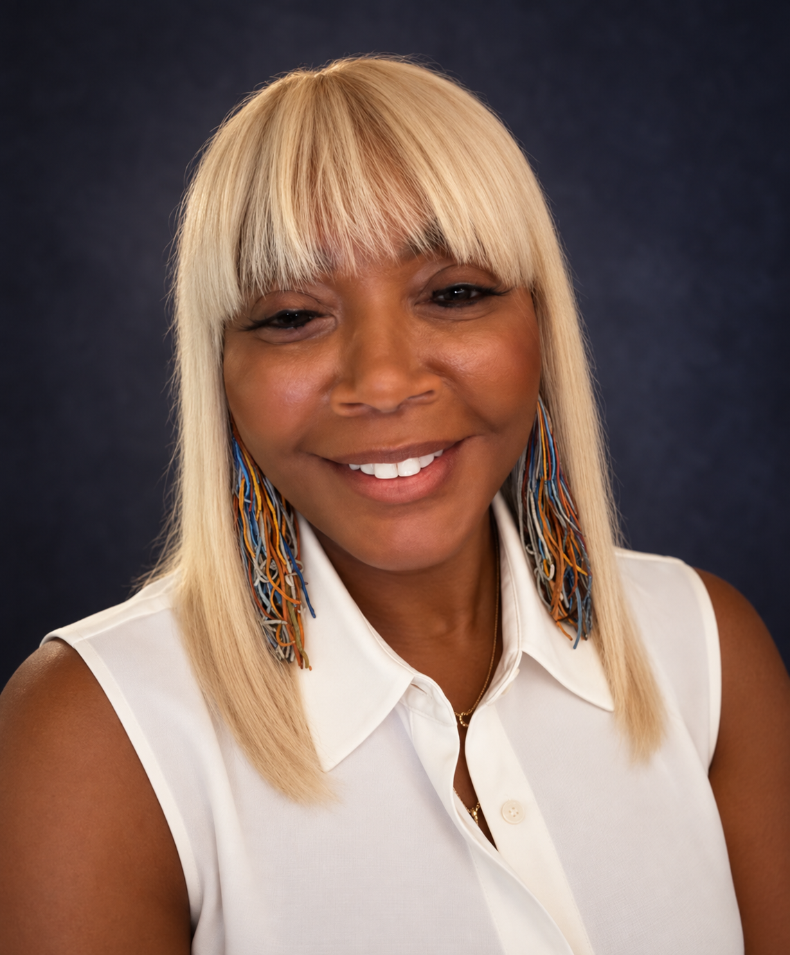 Portrait of Shelley Parker Mack, LPN, Founder and President of Visions of Change Foundation, smiling in a white sleeveless blouse